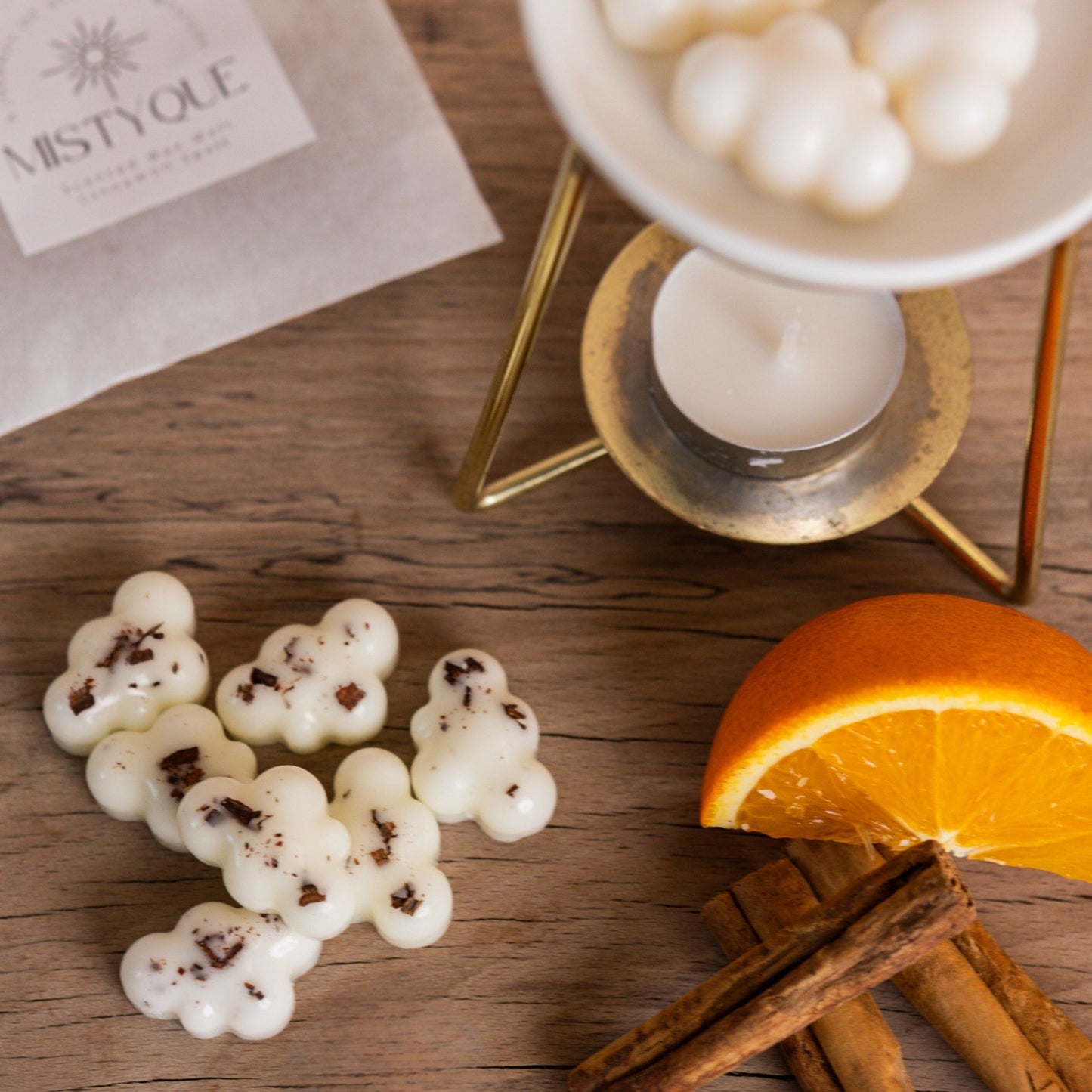 Close-up of cinnamon spell wax melts with orange slice and wax warmer