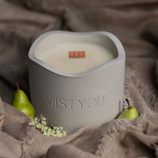 Mistyque candle in light grey concrete pot with wooden wick, styled with pear and elderflower — Pear in Bloom standard candle