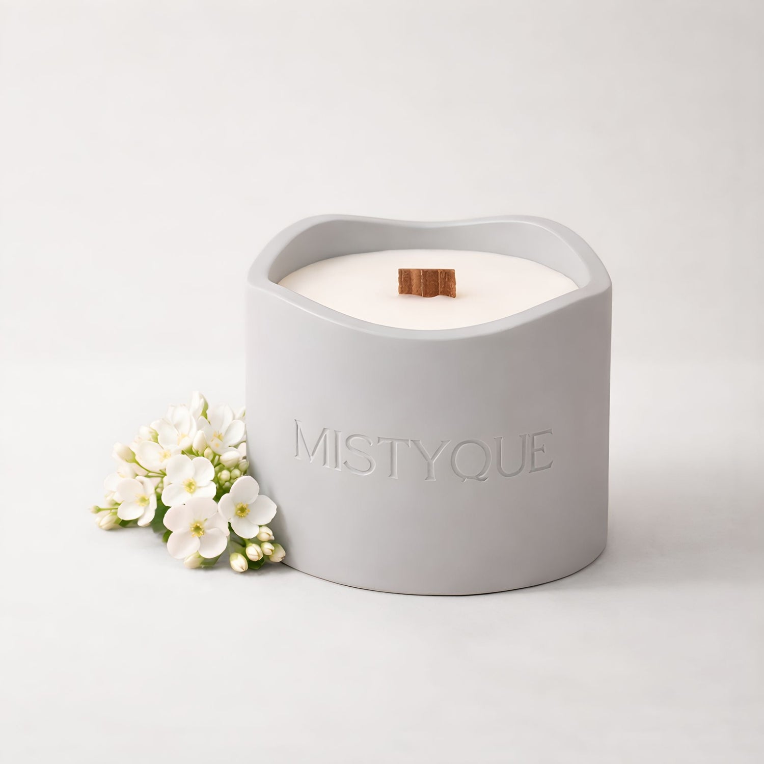 Aromatherapy candle in Mistyque ceramic pot with wooden wick, styled with orange blossom and soft fabric