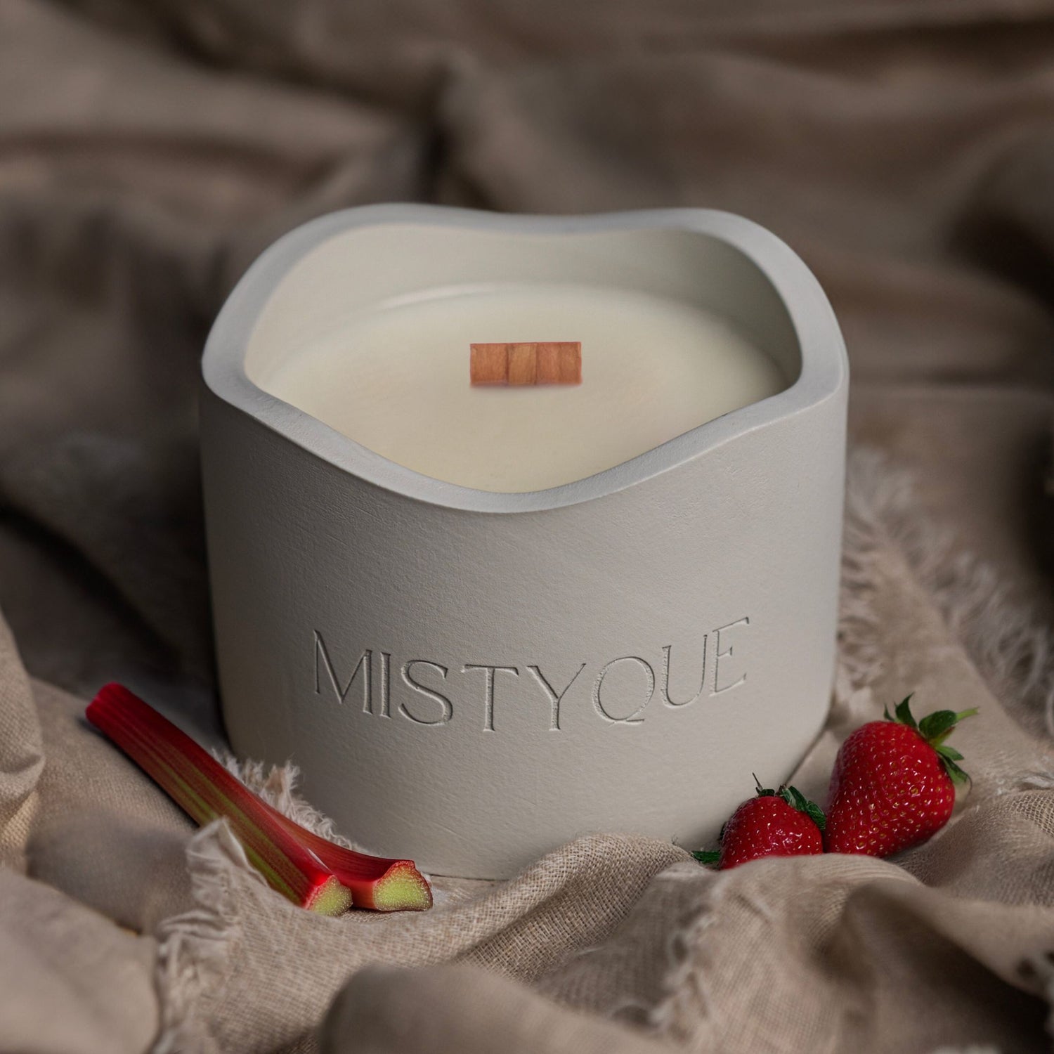 Mistyque candle in light grey concrete pot with wooden wick, styled with strawberries and rhubarb — Blush Hour standard candle